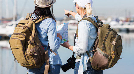 Due turiste con una mappa vicino al mare