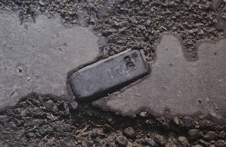Telefono cellulare a terra, opera della mostra Fossili Urbani