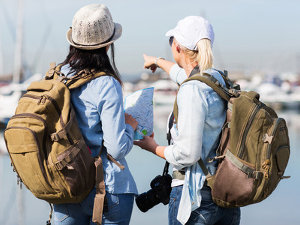Due giovani turiste con una mappa davanti al mare